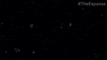 a group of asteroids are flying through space in a black background .
