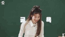 a group of girls sit at desks in a classroom with a sign that says twice on it