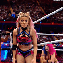 a woman with pink hair is standing in a ring .