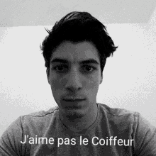 a young man is taking a selfie in a black and white photo with the words `` j'aime pas le coiffeur '' .