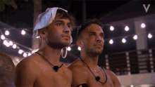 two shirtless men are standing next to each other with the letter v in the upper right corner