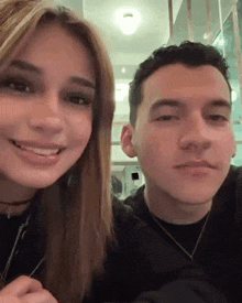 a man and a woman are smiling for the camera .