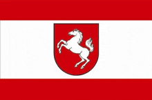 a red and white flag with a white horse on a red shield .