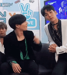 a group of young men are sitting in front of a sign that says bap love
