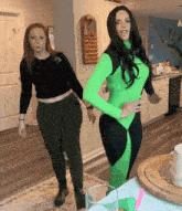 a woman in a green outfit is standing next to another woman in a black shirt