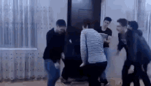 a group of young people are dancing in a living room .