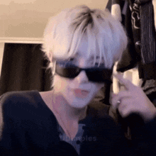 a man wearing sunglasses is making a funny face .