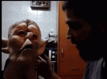 a man is putting a mask on another person 's face