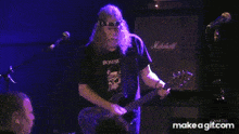 a man is playing a guitar in front of a marshall amp