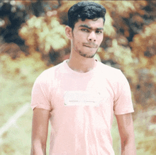 a young man wearing a pink shirt with a white arrow on the front
