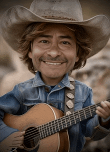 a man wearing a cowboy hat is holding a guitar and smiling