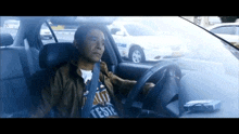 a man driving a car with a t-shirt that says teste