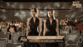 a couple of women standing next to each other in front of a crowd at the kazz awards