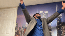 a man in a suit and blue shirt with his arms outstretched in front of a city skyline