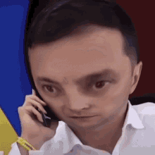 a man in a white shirt is talking on a phone
