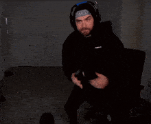 a man wearing headphones and a bandana with the letter s on it