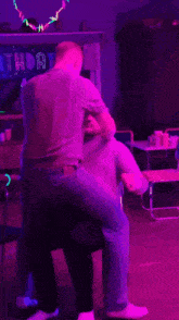 two men dancing in front of a birthday sign