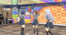 three girls dancing in front of a book store