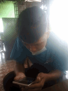 a man wearing a blue shirt with the letter x on it