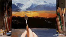 a person is holding a palette knife in front of a painting that says fred
