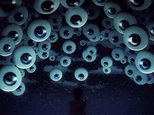 a bunch of eyes are hanging from the ceiling with empty.com written on the bottom right