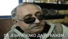 a man with a mustache wearing sunglasses says pa jebiga kako da ti kajem