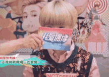 a person covering their face with a sign that says nct dream on it