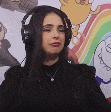 a woman wearing headphones and a necklace looks sad
