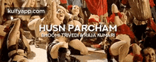 a group of women are dancing in front of a banner that says husn parcham .