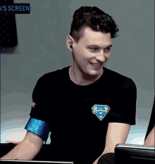 a man wearing ear buds and a black shirt with a superman logo on it