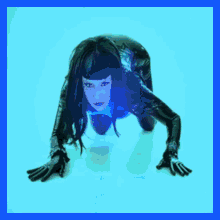 a woman in a black catsuit is crawling on the ground