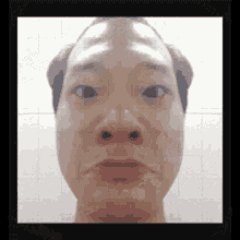 a close up of a man 's face with a bald head