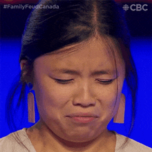 a close up of a woman 's face with the words family feud canada written on the bottom