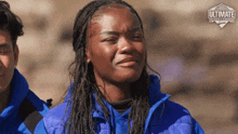 a woman wearing a blue jacket with the word ultimate written on it