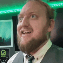 a man with a beard is smiling in front of a poster that says la on it
