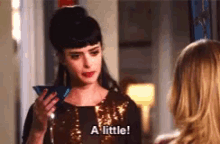 a woman is holding a martini glass and says a little