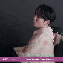 a man is standing in front of a sign that says key and one touch two dollar