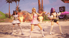 three women are dancing on a beach and one is pointing