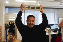 a man in a black sweater is holding a brick in his hands