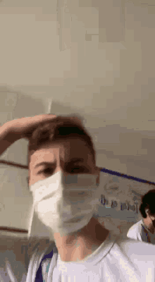 a man wearing a face mask is standing in a room .
