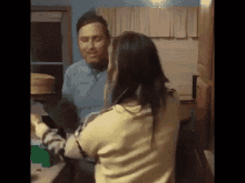 a man and a woman are sitting at a table in a kitchen .