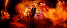 a woman with red hair is standing in the middle of a fire .