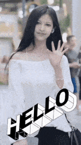 a woman in a white off the shoulder top waves her hand with the word hello behind her