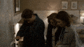 a man and two women are looking into a room with a door that has the number 2 on it