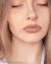 a close up of a woman 's face and neck with her eyes closed