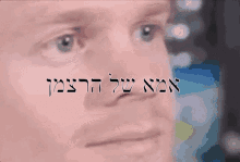 a close up of a man 's face with the words in hebrew above it