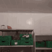 green crates are stacked on top of each other on shelves