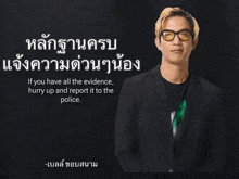 a man wearing glasses stands in front of a black background