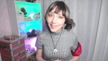 a woman in a plaid shirt is standing in front of a shelf with stuffed animals