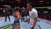 two female fighters are standing in a ring and one of them has a monster energy logo on her shirt